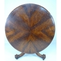 A Victorian walnut veneered breakfast table with unusual base, the tilt top on a baluster column and... 