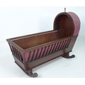 A Victorian mahogany rocking crib, with turned spindle sides, hood to one end with brass thistle fin... 