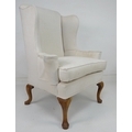A wing back armchair, with high back and outswept arms, raised on cabriole legs, recently upholstere... 