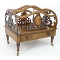 A Victorian walnut veneered Canterbury with lyre pierced sides, oval cartouche with scrolls to front... 