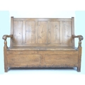 A Victorian pine settle, with five panel back, scroll end open arms supported on turned columns, the... 