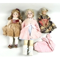 A collection of three late 19th century / early 20th century and later dolls, comprising a bisque he... 