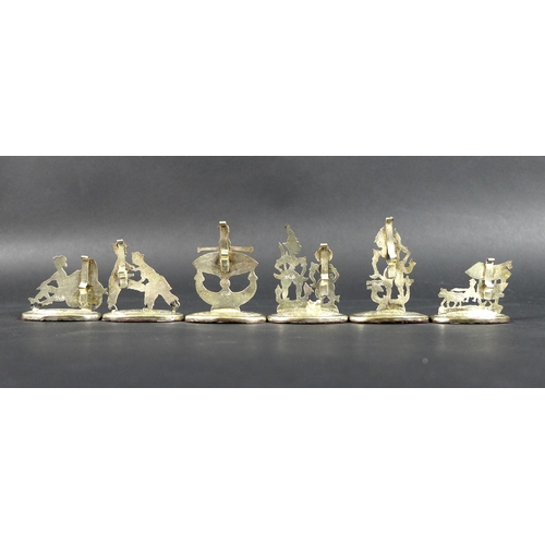 25 - A set of six Malaysian silver name or menu holders, all depicting figures in traditional dress at va... 