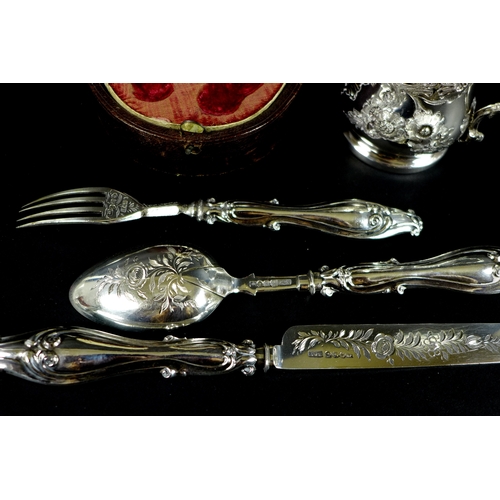 59 - A Victorian silver christening set, comprising cup, knife, fork and spoon, all foliate engraved, the... 