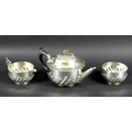 A Victorian three piece silver tea set comprising teapot, milk jug and sugar bowl, all chased and em... 
