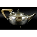 An Arts & Crafts silver teapot, of squat ovoid form with shaped handle and raised on three feet, Alb... 