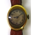 An early 20th century 18ct gold lady's watch in unusual oval shaped case with engraved scroll detail... 