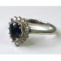 An 18ct white gold, sapphire and diamond dress ring, with pear cut central sapphire of approximately... 