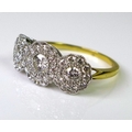 A 18ct gold and diamond ring, the three main diamonds encircled by diamond chips to form three flowe... 