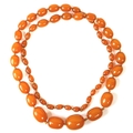 A string of early to mid 20th century toffee amber beads, beads 26 by 21mm and smaller, 66g.