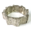 A Danish silver cuff bangle formed of eight connected panels with bark texturing, marked Anton Miche... 