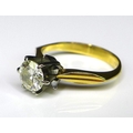 An 18ct gold and diamond solitaire ring of modernist form, white metal starburst setting with cutawa... 