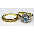 An 18ct gold, diamond and aquamarine ring, the central round cut aquamarine of 6mm diameter and surr... 