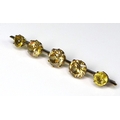 A gold bar brooch set with five graduated citrines, central claw set stone 8.8 by 6.2mm, smallest 6.... 