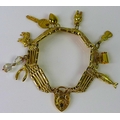 A 9ct gold five bar gate bracelet with various charms attached, scrolling foliate engraved heart pad... 
