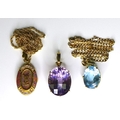 A group of three 9ct gold pendants, comprising one set with a large lilac stone, the second set with... 
