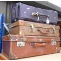 A group of three vintage suitcases, comprising a brown leather case, a slightly smaller case with le... 