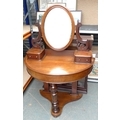 A 20th century mahogany dressing table of demi lune form, the oval mirror held within scrolling supp... 