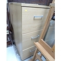 A group of three modern beech effect office three drawer filing cabinets, with key. (3)
