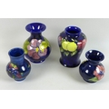 A group of four Moorcroft vases, comprising hibiscus, plum, orchid and clematis, all marked Moorcrof... 