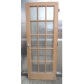 A modern pine door, with fifteen rectangular glass panels, 3.5 by 76.5 by 197.5cm.