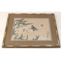 A 19th century Japanese silk painting depicting butterflies amidst blossoms, framed.