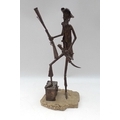 A modern metal figure of a pirate, modelled standing with right foot raised on a barrel and holding ... 