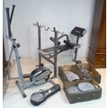A weight lifting bench and an aerobic exerciser, with angled bar and various weights, and a badminto... 