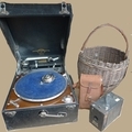 A Columbia Granfola turn table player, together with two vintage cameras and a wicker basket.