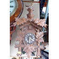 A carved wooden cuckoo clock, with stag's head surmount and white applied Roman numerals, with pendu... 