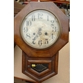 An octagonal cased wall clock, silvered dial, glazed door below, twin train movement, with pendulum,... 