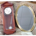 A modern wall clock and oval gilt framed mirror, also modern.