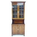An early 19th century mahogany display cabinet, the twin glass paned doors enclosing shelves with br... 