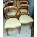 A set of four reproduction balloon back dining chairs with cream upholstered seats.