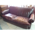 A vintage chocolate brown leather two seater sofa.