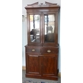 A late 19th or early 20th century glazed mahogany bookcase, shaped pediment, two drawers and cupboar... 