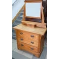 An Edwardian oak dressing chest, mirror over three drawers.