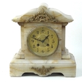 A soapstone mantel clock, brass dial with Arabic numerals, 27cm high.