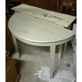 A cream painted narrow side table with single drawer, together with a cream painted demi-lune side t... 