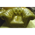A green leather Chesterfield style three seater sofa, circa 1970, together with a matching armchair.... 