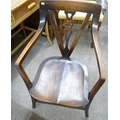 An oak open armchair, circa 1950, with wheelback pierced splat and crossed back legs.
