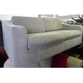 A modern two seater sofa, with grey fabric upholstery.
