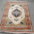 A modern rug with salmon pink ground, blue and cream geometric decoration, approx 6 by 8ft.