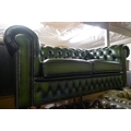 A modern Victorian style green leather two seater sofa.