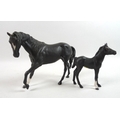 A Beswick figurine modelled as a black horse and another as a black foal. (2)