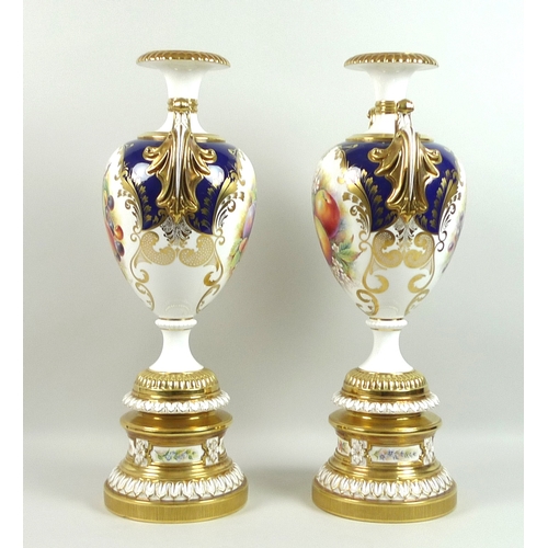 60 - A pair of large modern Royal Worcester pedestal vases, foliate clasped twin handles, decorated in a ... 