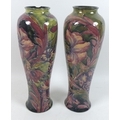 A pair of William Moorcroft vases, circa 1915, of slender baluster form, decorated in the 'Spanish' ... 