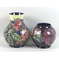 Two Moorcroft Pottery vases, one of baluster form, decorated in the 'Simeon' pattern, impressed key ... 
