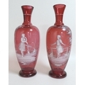 A pair of ruby glass baluster vases by Mary Gregory, each pate sur pate decorated with a girl, band ... 