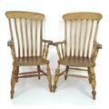 A pair of early 20th century slat back elbow kitchen chairs, 56 by 62 by 114cm high, and 61 by 65 by... 